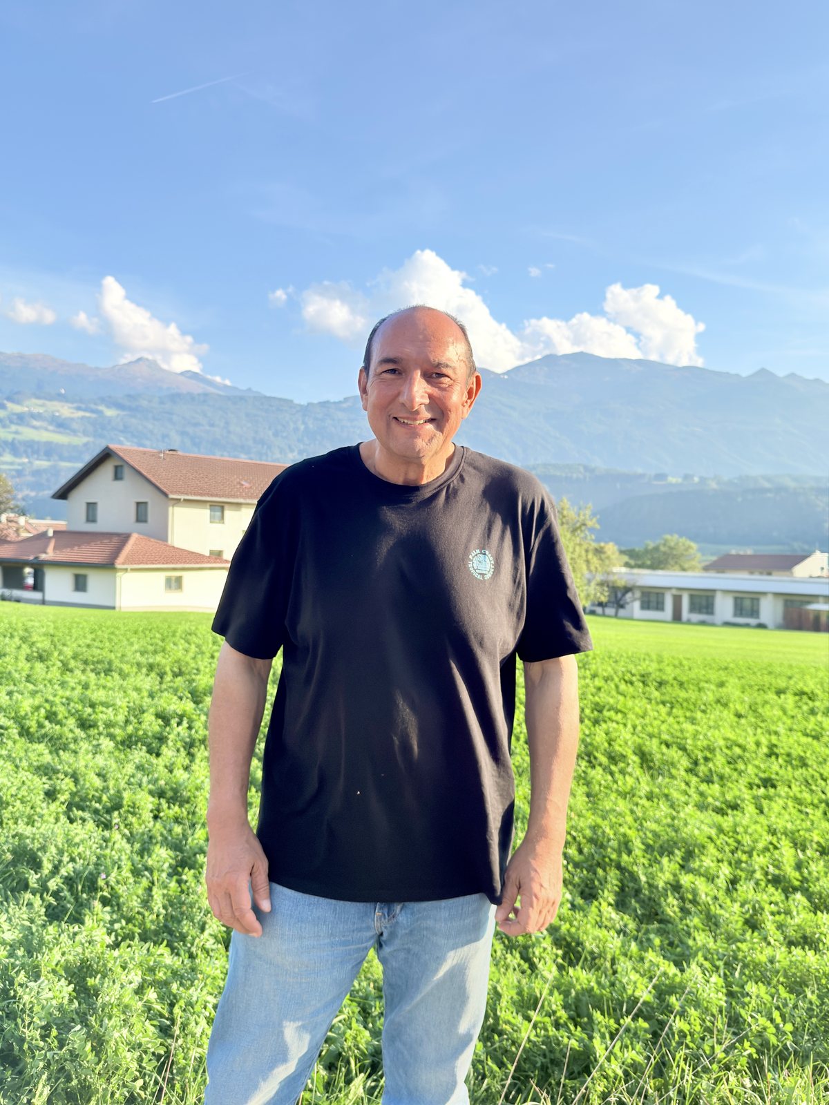 Andreas Csobod auf einer grünen Wiese vor den Bergen