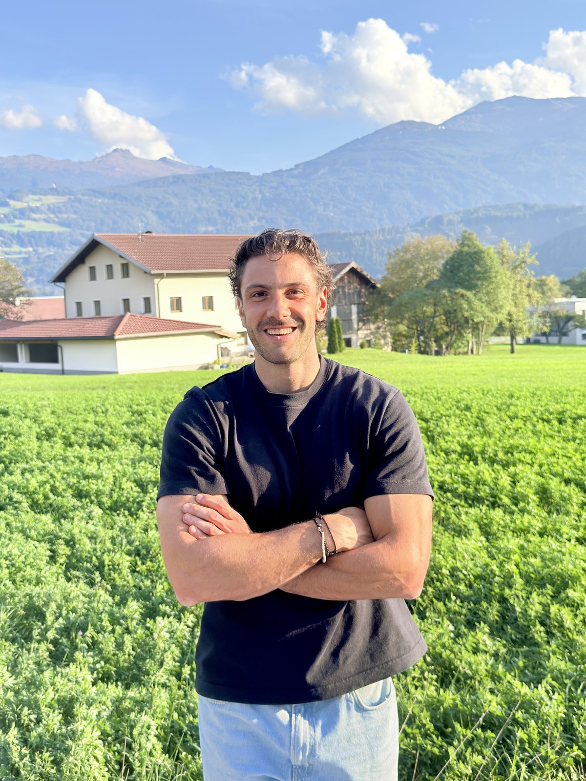 Moritz Stuffer auf einer grünen Wiese vor den Bergen